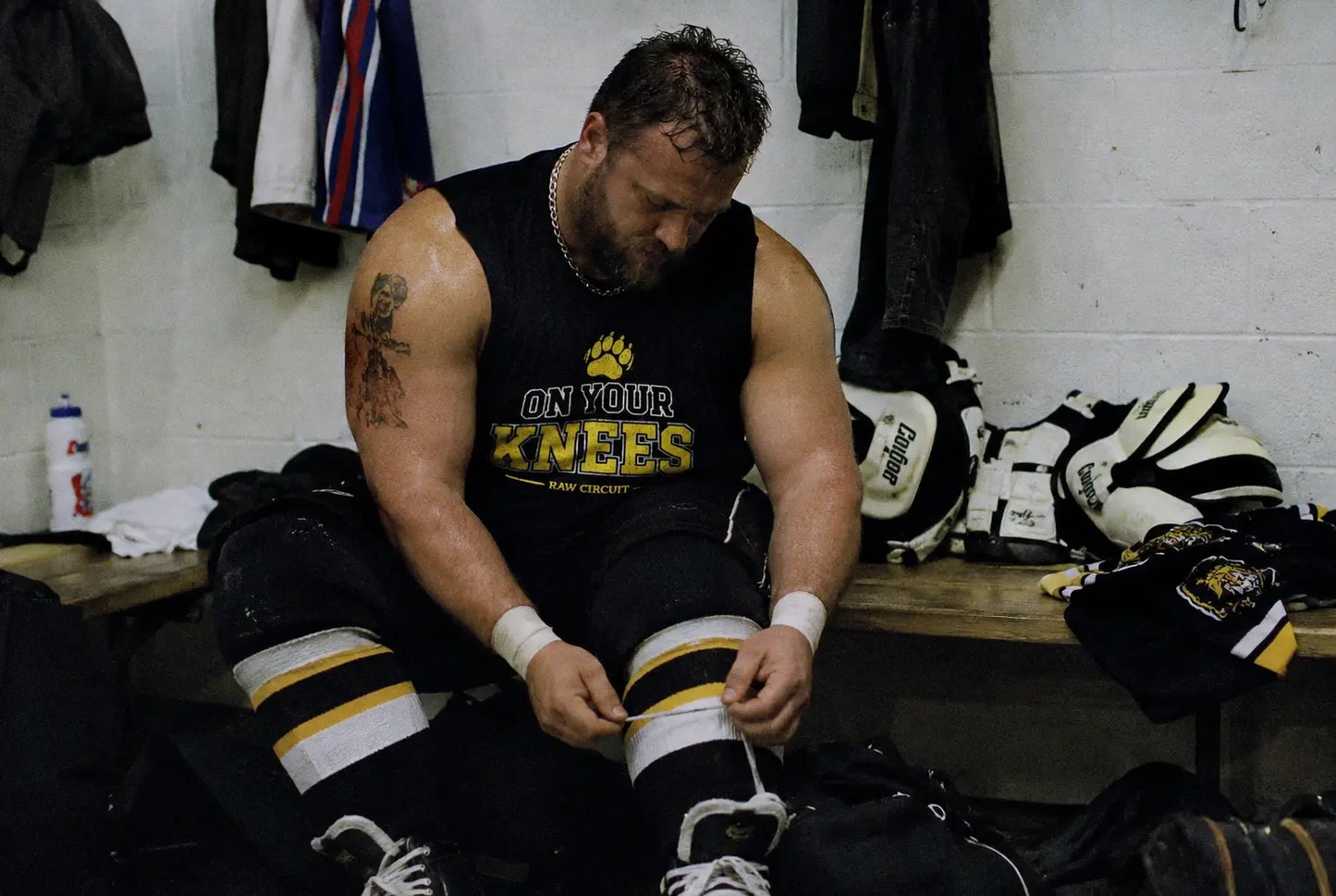 Locker room athlete wearing “on your knees” muscle tank 