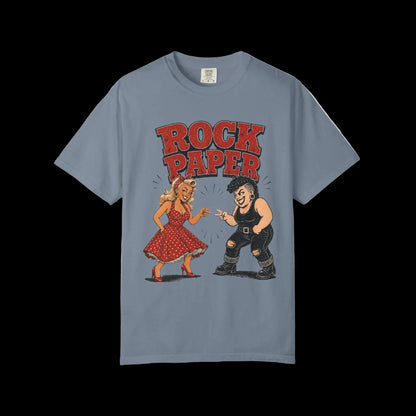 Vintage rockabilly pinup and tattooed character facing off beneath Rock Paper typography on blue Jean colored shirt