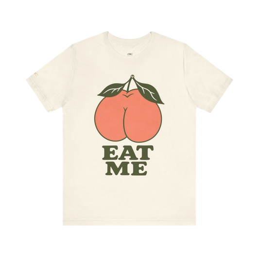 Natural EAT ME graphic tee with oversized coral peach, olive leaves and retro lettering.