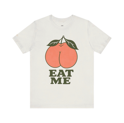 Vintage White EAT ME graphic tee with oversized coral peach and dark olive typography.