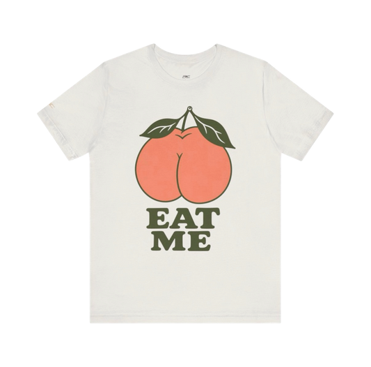 Vintage White EAT ME graphic tee with oversized coral peach and dark olive typography.