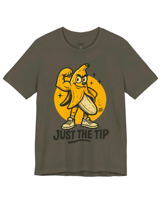 RAW CIRCUIT Just the Tip graphic tee in army green, featuring a muscular cartoon banana wearing sneakers, a yellow circular backdrop, and bold black lettering.