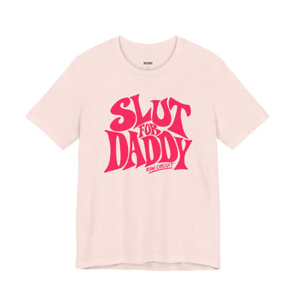 Soft Pink Bella+Canvas graphic T-shirt with large retro SLUT FOR DADDY lettering and RAW CIRCUIT branding on the front.